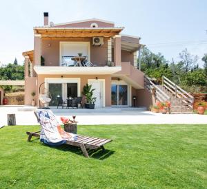 a house with a lawn in front of it at Venetis Family House in Gouvia