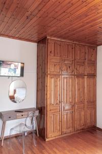 a wooden closet in a room with a desk and a mirror at Join In Home in Pogoniá
