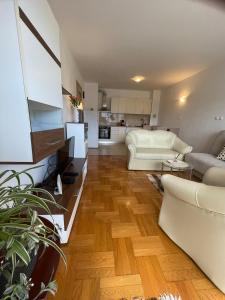 a living room with a white couch and a kitchen at Apartment Sara in Solin