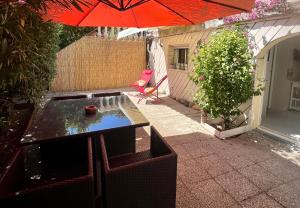 a small backyard with an umbrella and a pond at Le Maquis in Alata