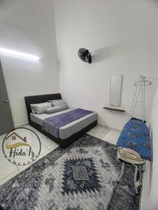 a bedroom with a bed and a chair and a rug at HidaIz Homestay Juasseh in Juasseh