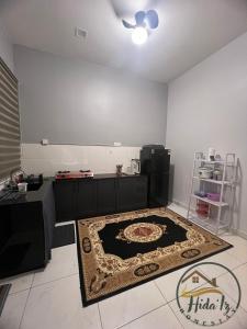 a kitchen with a table and a rug on the floor at HidaIz Homestay Juasseh in Juasseh +2 photos
