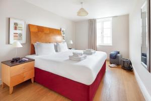 a bedroom with a large bed with a red and white bedvisor at Marlin Apartments London City - Queen Street in London