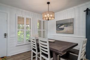 a dining room with a wooden table and a chandelier at 1147 Summerwind Cottage in Seabrook Island