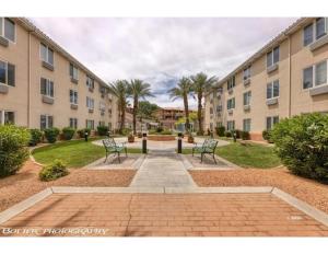 a courtyard with two benches in front of a building at Highland Estates Condotel in Mesquite