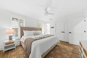 a white bedroom with a large bed and white cabinets at 1147 Summerwind Cottage in Seabrook Island