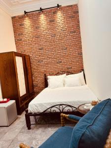 a bedroom with a brick wall and a bed at Hà Nội Mái Hiên Home in Hanoi