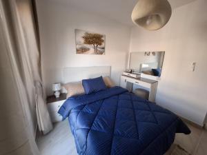 a bedroom with a blue bed and a desk at Modern City Apartment in Cairo