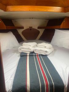 two folded towels on a bed on a boat at Bily Boat Praia da Rocha Portimão in Portimão
