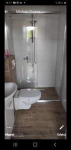a bathroom with a shower with a toilet and a sink at Przystanek Dąbki in Dąbki