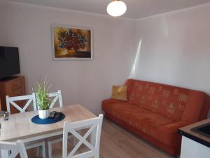 a living room with a red couch and a table at Przystanek Dąbki in Dąbki