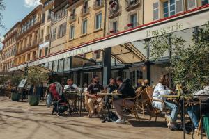 a group of people sitting at tables outside a building at La Bastide de Paula in Aix-en-Provence