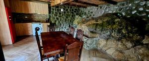 a kitchen with a table and chairs and a stone wall at Wooden Cottage '' Lailashi '' in Surmushi +49 photos