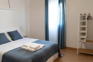 a bedroom with a bed with two towels on it at Geres Andorinhas House in Vieira do Minho