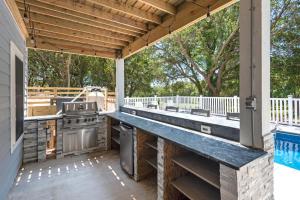 une cuisine extérieure avec un grill et une cuisinière sur une terrasse dans l'établissement Blue Skies, à Corolla