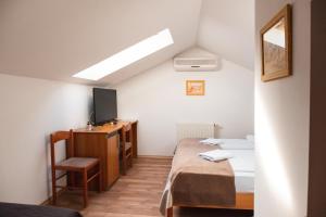 a small room with two beds and a tv at Hotel Keltika in Izola +31 photos