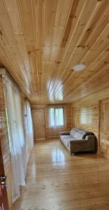 a large room with a bed in a wooden cabin at Wooden Cottage '' Lailashi '' in Surmushi