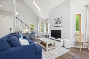 a living room with a blue couch and a tv at Aurora in Duck +36 photos