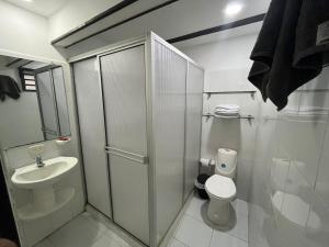 une salle de bain blanche avec toilettes et lavabo dans l'établissement Primavera house - Habitaciones Full amobladas, à Ibagué