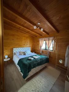 a bedroom with a bed in a wooden cabin at Planinska kuća SAMAK in Sarajevo