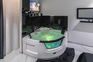 a jacuzzi tub in a bathroom with green water at Amour - House with Private Jacuzzi in Rosolini