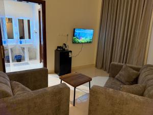 a living room with two couches and a flat screen tv at استديو كلاود in Al Baha
