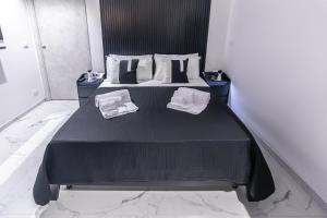 a bedroom with a black bed with two pillows at Amour - House with Private Jacuzzi in Rosolini +29 photos