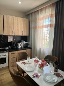 a kitchen with a table with plates and wine glasses at GenAl Apartaments in Tirana +38 photos