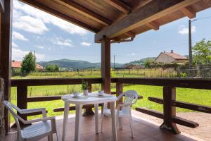 a white table and chairs on a porch with a view at La casuca del norte in Hornedo