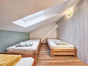 two beds in a room with a skylight at Gunram Mazury in Okowizna