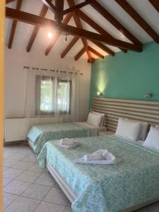 a bedroom with two beds in a room at Maniatis Garden in Achladies
