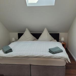 a large white bed with two pillows on it at Scheune Am alten Posthof Lieser in Lieser