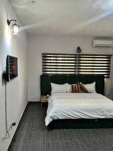 a bedroom with a large bed with a green headboard at Stj Luxury Hotels in Ilorin
