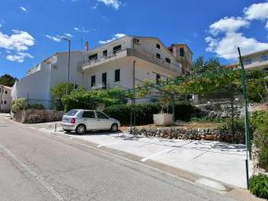 a white car parked in front of a building at Apartman Dide in Igrane