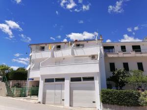 a white apartment building with two garage doors at Apartman Dide in Igrane +2 photos