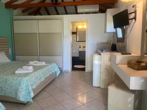 a small bedroom with a bed and a kitchen at Maniatis Garden in Achladies