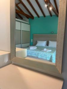 a bedroom with a bed with a large mirror at Maniatis Garden in Achladies
