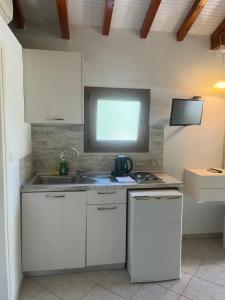 a kitchen with a sink and a tv on the wall at Maniatis Garden in Achladies