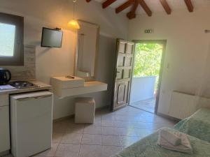 a kitchen with a sink and a mirror and a door at Maniatis Garden in Achladies