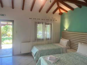 a bedroom with two beds and a window at Maniatis Garden in Achladies