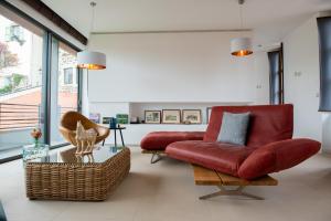 Una sala de estar con un sofá rojo y una silla. en La Plâtrière, appartement classé 5 étoiles, avec garage en ville haute du Puy, en Le Puy en Velay
