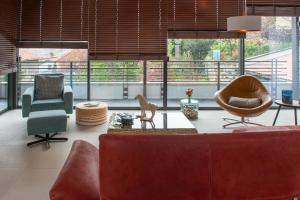 Una sala de estar con un sofá y sillas y ventanas. en La Plâtrière, appartement classé 5 étoiles, avec garage en ville haute du Puy, en Le Puy en Velay 47 fotos más