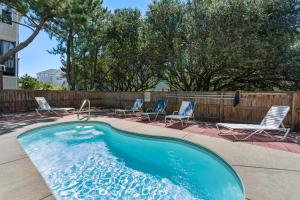 una piscina con tumbonas y una valla en Bos Bungalow, en Corolla