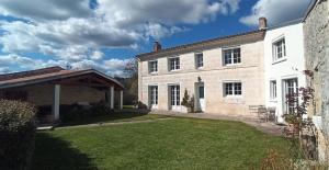 a large brick house with a grass yard at Les rives du Rochefollet in Saint-Vaize