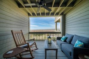 a screened in porch with a couch and a table at 1307 Pelican Watch Villa in Seabrook Island