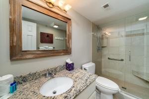 a bathroom with a sink and a toilet and a mirror at 1307 Pelican Watch Villa in Seabrook Island +33 photos
