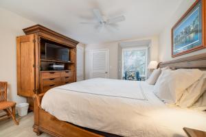 1 dormitorio con 1 cama y vestidor con TV en 1304 Pelican Watch Villa, en Seabrook Island 16 fotos más