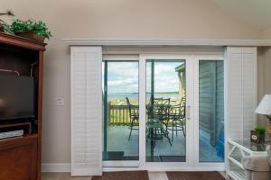 a room with a sliding glass door with a table and chairs at 1304 Pelican Watch Villa in Seabrook Island
