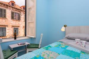 Stradun View En Suite Rooms & Studio في دوبروفنيك: غرفة نوم بها سرير ونافذة
