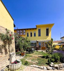 a large yellow house with a garden in front of it at Mediterrán Vendégház in Kecskemét